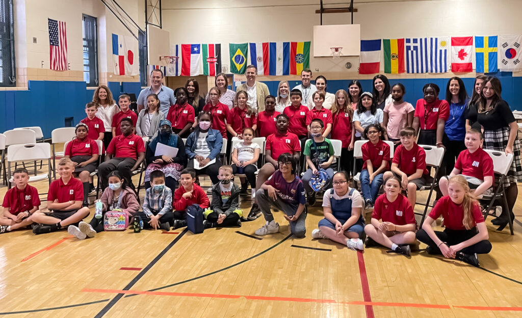 School leaders, teachers, and students from P.S. 60, along with St. Cadoc’s and St. Peter’s primary schools (Wales, U.K.), gather for a group photo inside P.S. 60’s gymnasium. The Writing Revolution's Co-Executive Directors — Toni-Ann Vroom (top row; sixth from left) and Dina Zoleo (top row; left) were also present. 